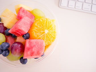 Fresh Fruit Salad Bowl on White Desk with Keyboard