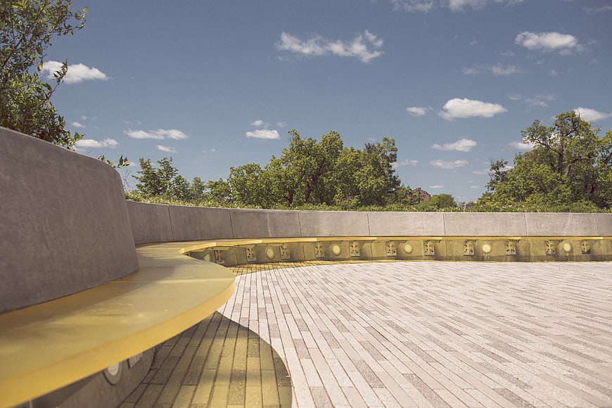 Modern curved concrete bench in park with blue sky