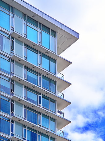 Modern Glass Building Facade with Blue Sky Background