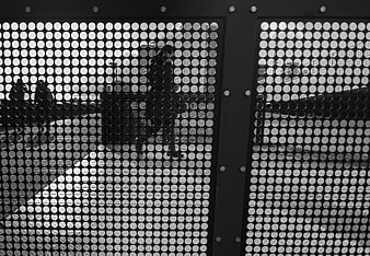 Black and white perforated metal screen with urban reflections