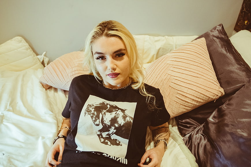 Blonde woman relaxing on bed with graphic t-shirt