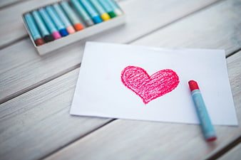 Red heart drawn with oil pastel on white paper