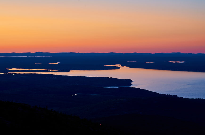 Serene Sunset Over Lake and Forested Hills
