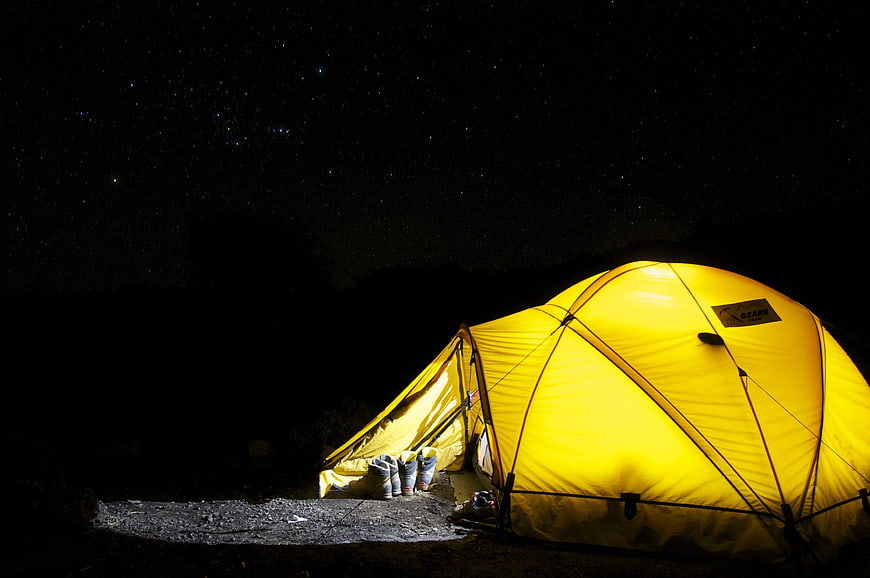 Yellow Camping Tent Glowing Under Starry Night Sky
