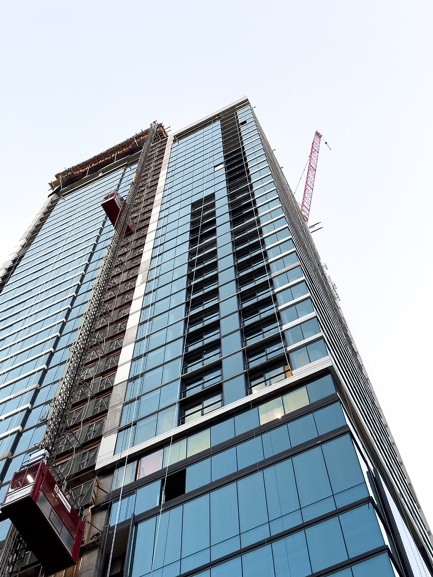 Low angle view of modern glass skyscraper under construction
