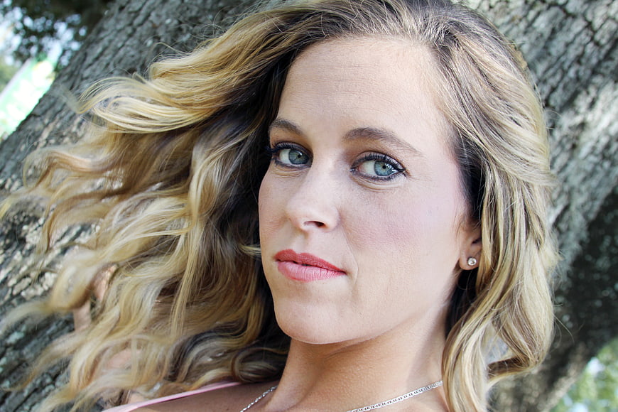Close-up portrait of blonde woman with blue eyes outdoors