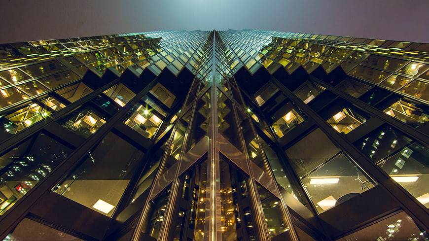 Low angle view of modern glass skyscraper at night