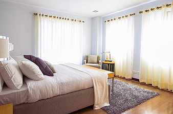 Bright Modern Bedroom with White Curtains and Purple Pillows
