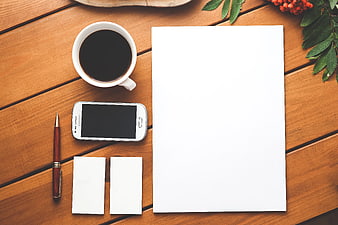 Flat lay workspace with coffee, smartphone, and blank paper
