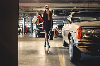 Fashionable Woman with Shopping Bags in Parking Garage