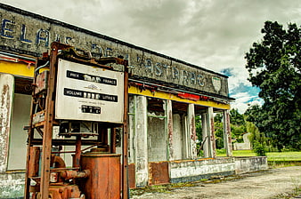Abandoned vintage gas station with rusty pump and peeling paint