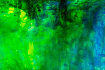 Abstract green and blue ink swirling in water background