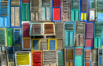 Colorful vintage wooden shutters on a weathered building facade