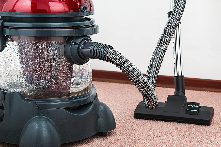 Red Canister Vacuum Cleaner Cleaning Pink Carpet