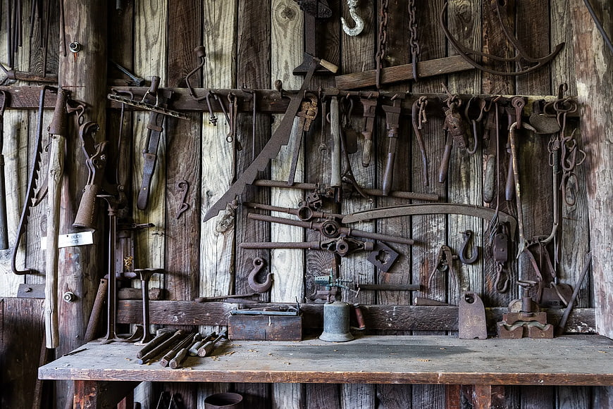 Vintage Rusty Farm Tools on Wooden Barn Wall
