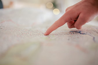 Close-up of hand pointing at location on city map