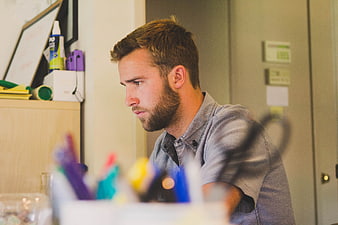 Focused Bearded Man Working at Desk in Office