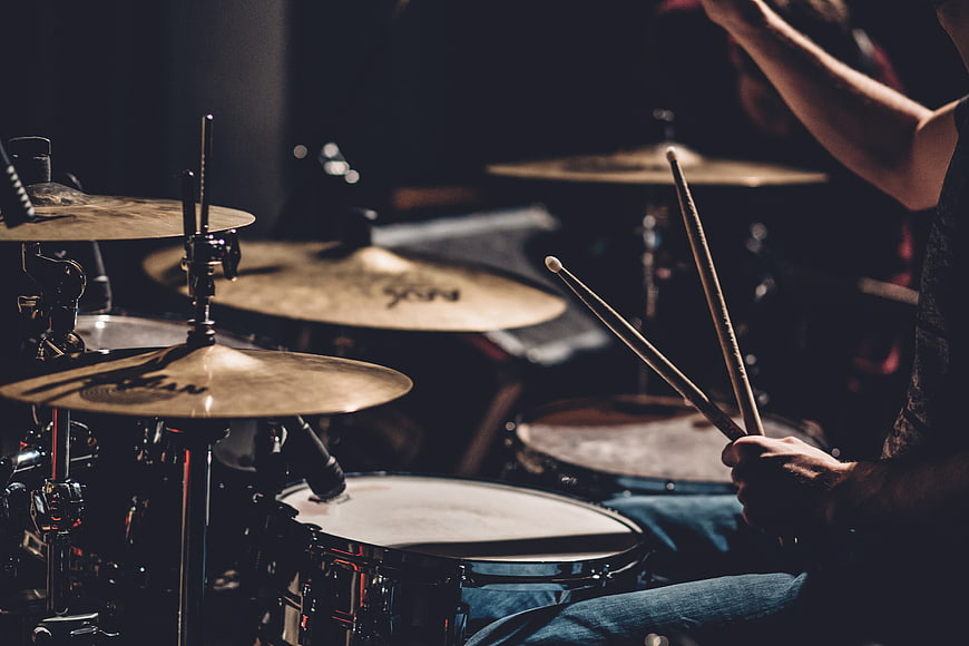 Musician Playing Drum Set in Dark Studio