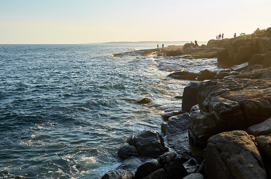 Scenic Rocky Coastline with Ocean Waves and People