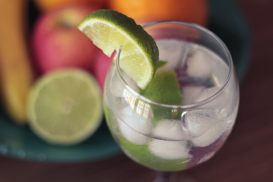 Refreshing Lime Water with Ice and Fresh Fruit Background