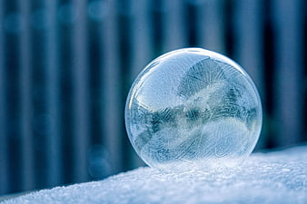 Frozen Ice Sphere on Snow with Intricate Frost Patterns