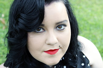 Close-up portrait of woman with black hair and red lipstick