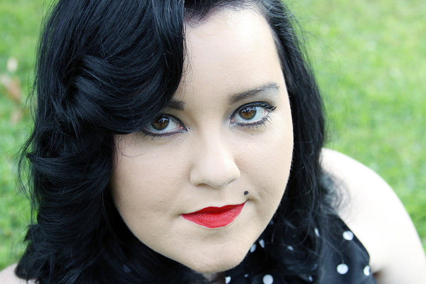 Close-up portrait of woman with black hair and red lipstick