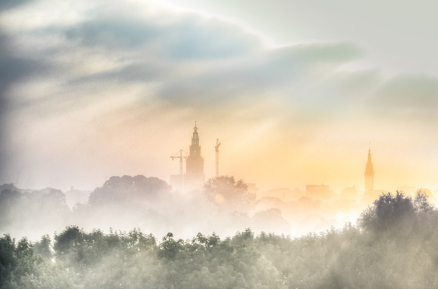 Misty sunrise over Groningen cityscape with church spires