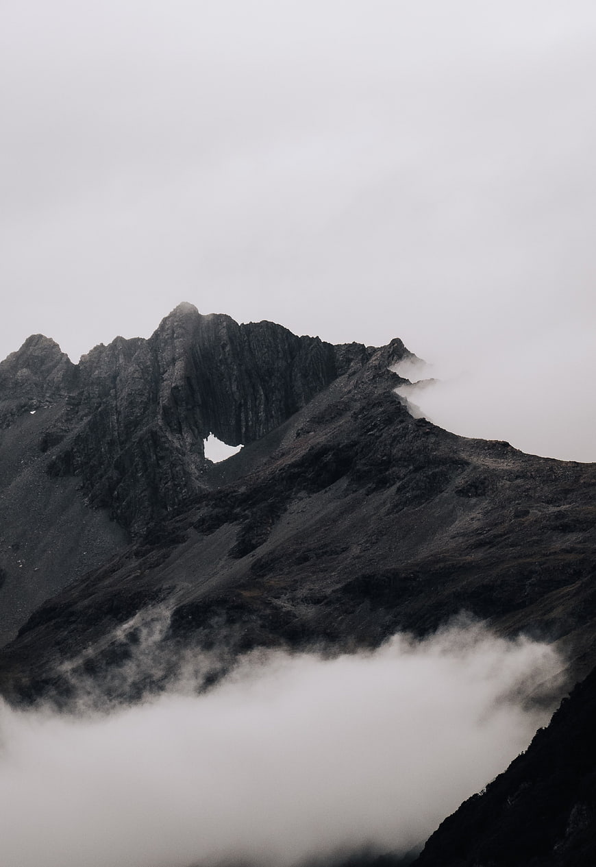 Dramatic Dark Mountain Peak Shrouded in Mist and Fog