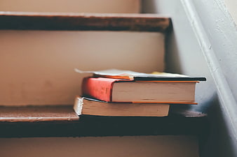 Stack of Books on Wooden Staircase Steps