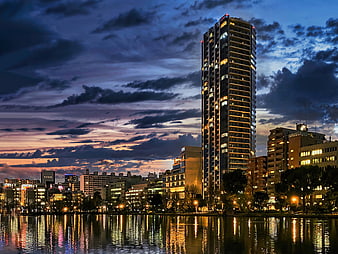 Modern high-rise apartment skyline at dusk with river reflections