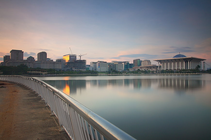 Serene Cityscape Reflection at Sunset with Curved Railing