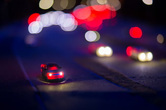 Toy car on road with colorful bokeh lights background