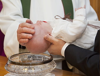 Close-up of baby baptism ceremony with water pouring