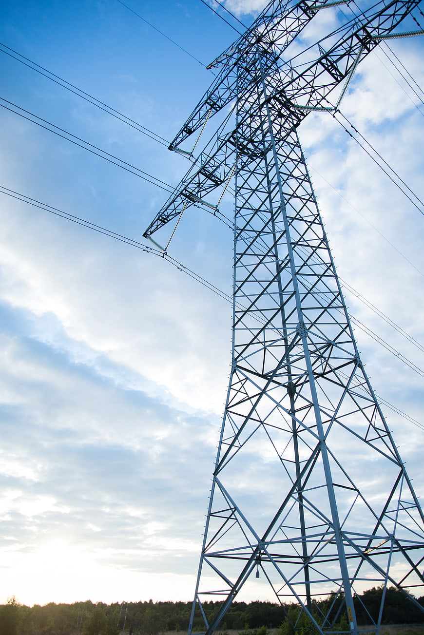 Low angle view of high voltage electricity pylon against blue sky