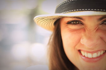 Close-up portrait of smiling woman wearing straw hat