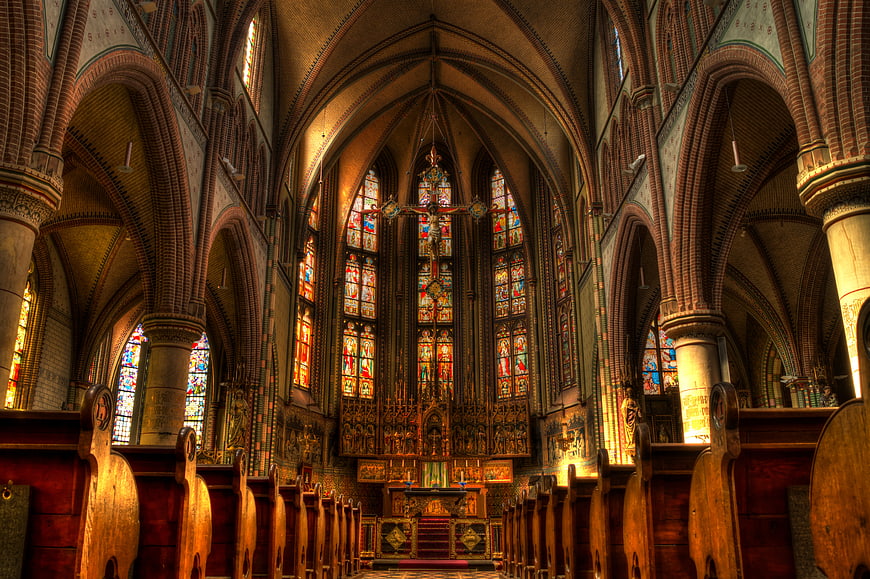 Gothic Church Interior with Stained Glass Windows and Brick Arches
