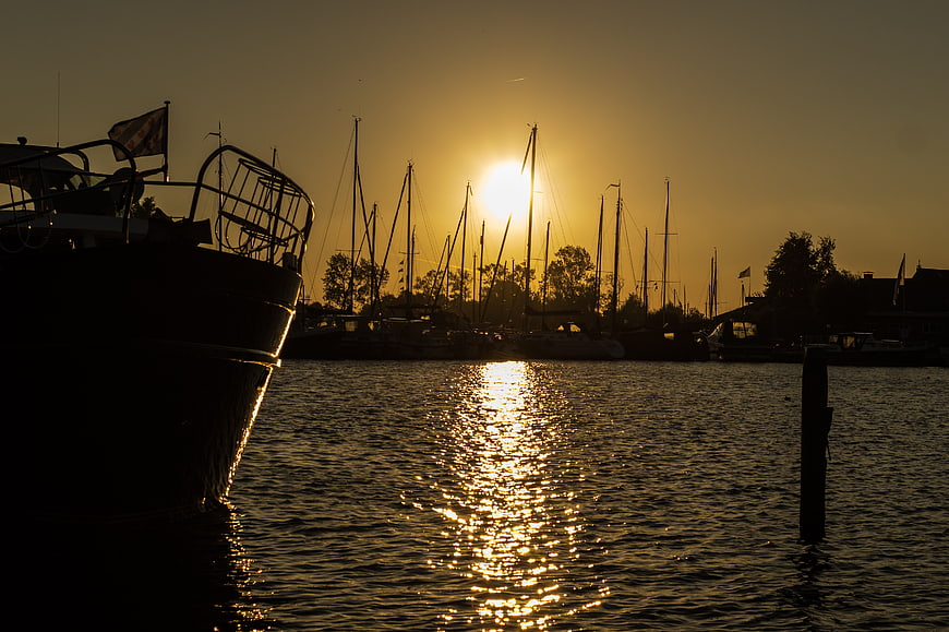 Silhouetted Sailboats in Harbor at Golden Sunset