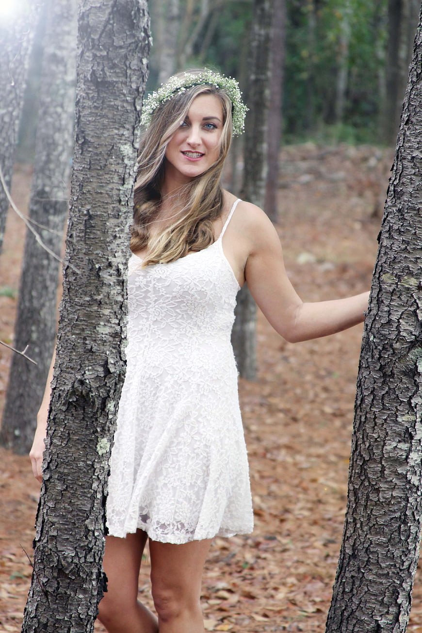 Woman in White Lace Dress with Flower Crown in Forest