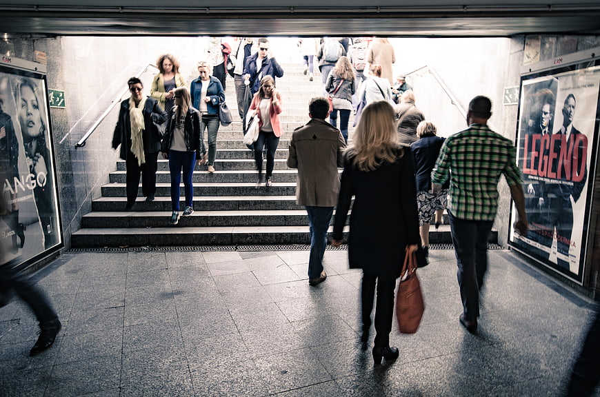 Crowd of people walking up stairs in urban subway station