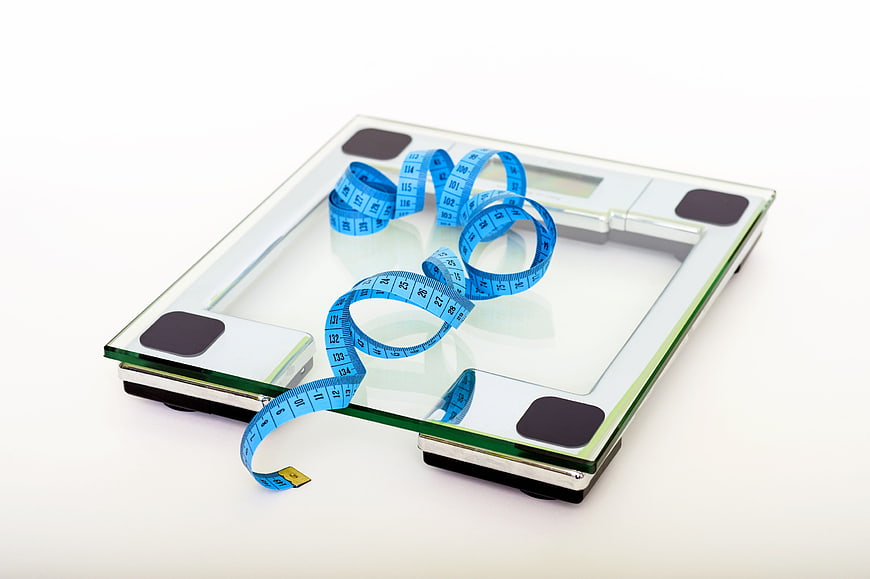 Blue measuring tape on glass bathroom scale