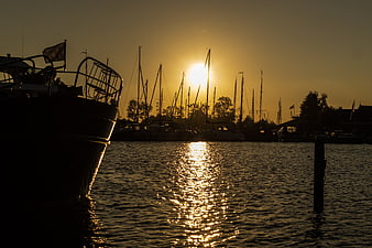 Silhouette of Sailboats in Harbor at Golden Sunset