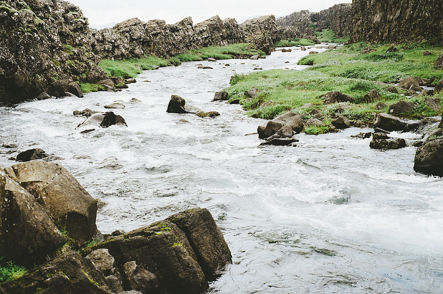 Flowing River Through Rocky Canyon with Green Banks