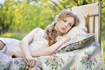 Woman in Lace Dress Lying on Floral Bed Outdoors