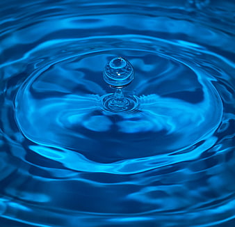 Macro shot of a blue water droplet creating ripples