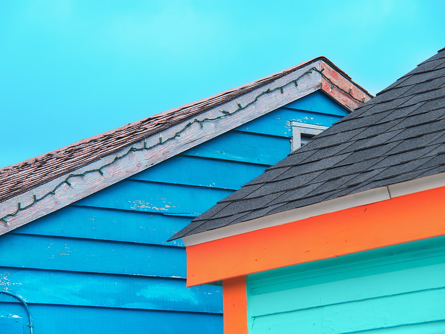Colorful House Roof Detail Against Blue Sky