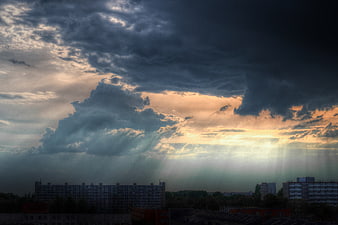 Dramatic sunset with sunbeams over city skyline