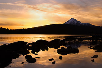 Golden Sunset Over Mountain Lake with Rocky Shoreline