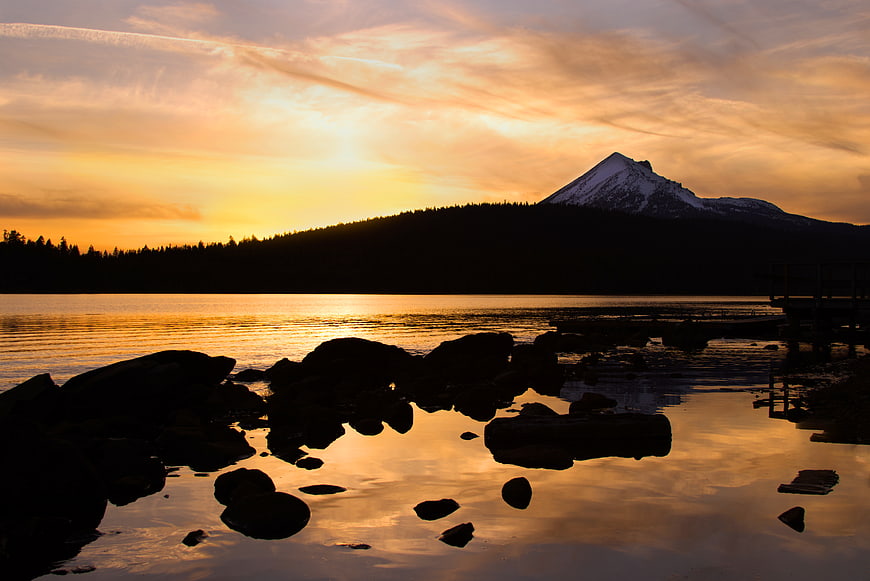 Golden Sunset Over Mountain Lake with Rocky Shoreline