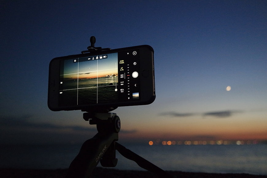 Smartphone on Tripod Filming Sunset Over Ocean